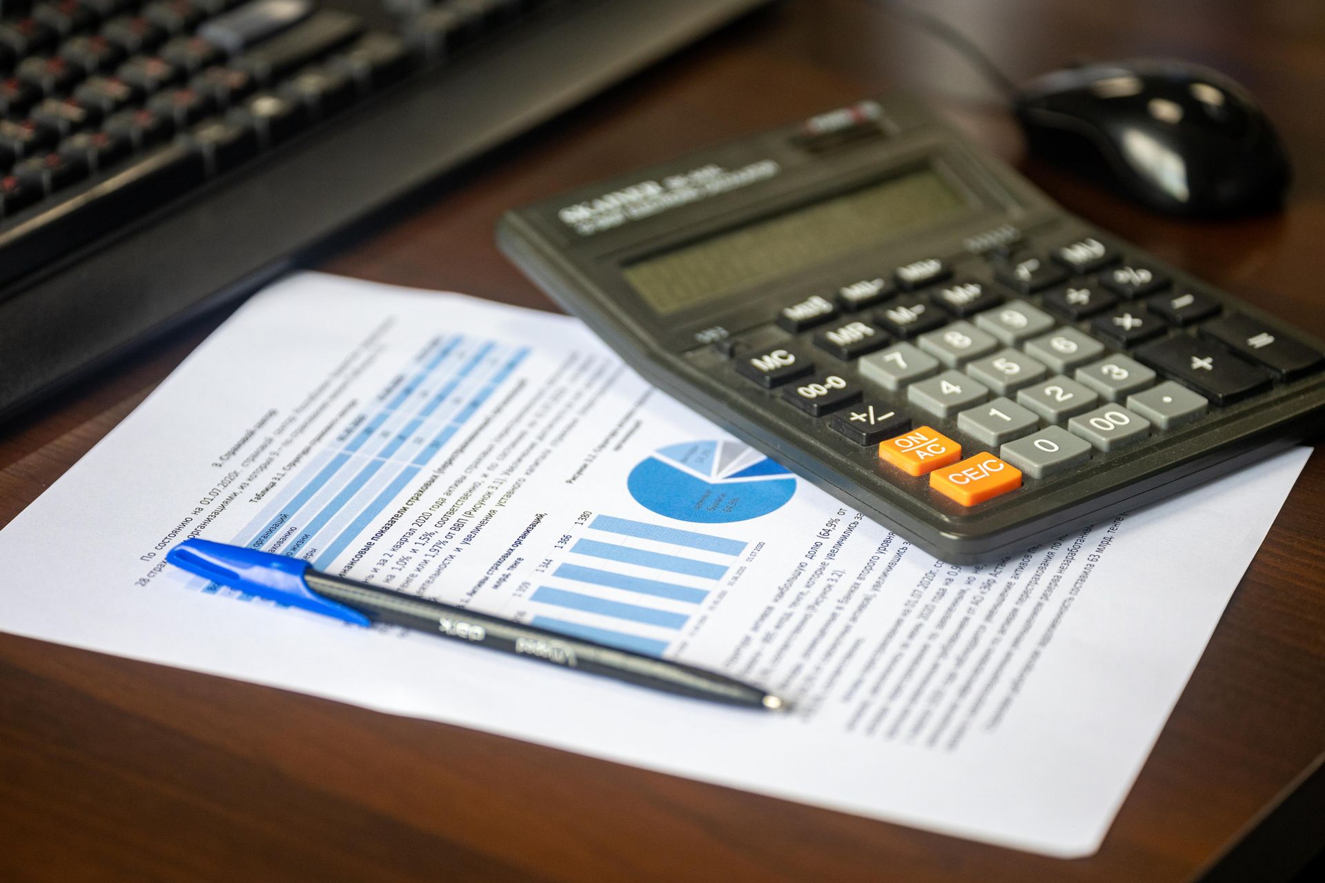 Payroll calculation with calculator, pen, and financial documents