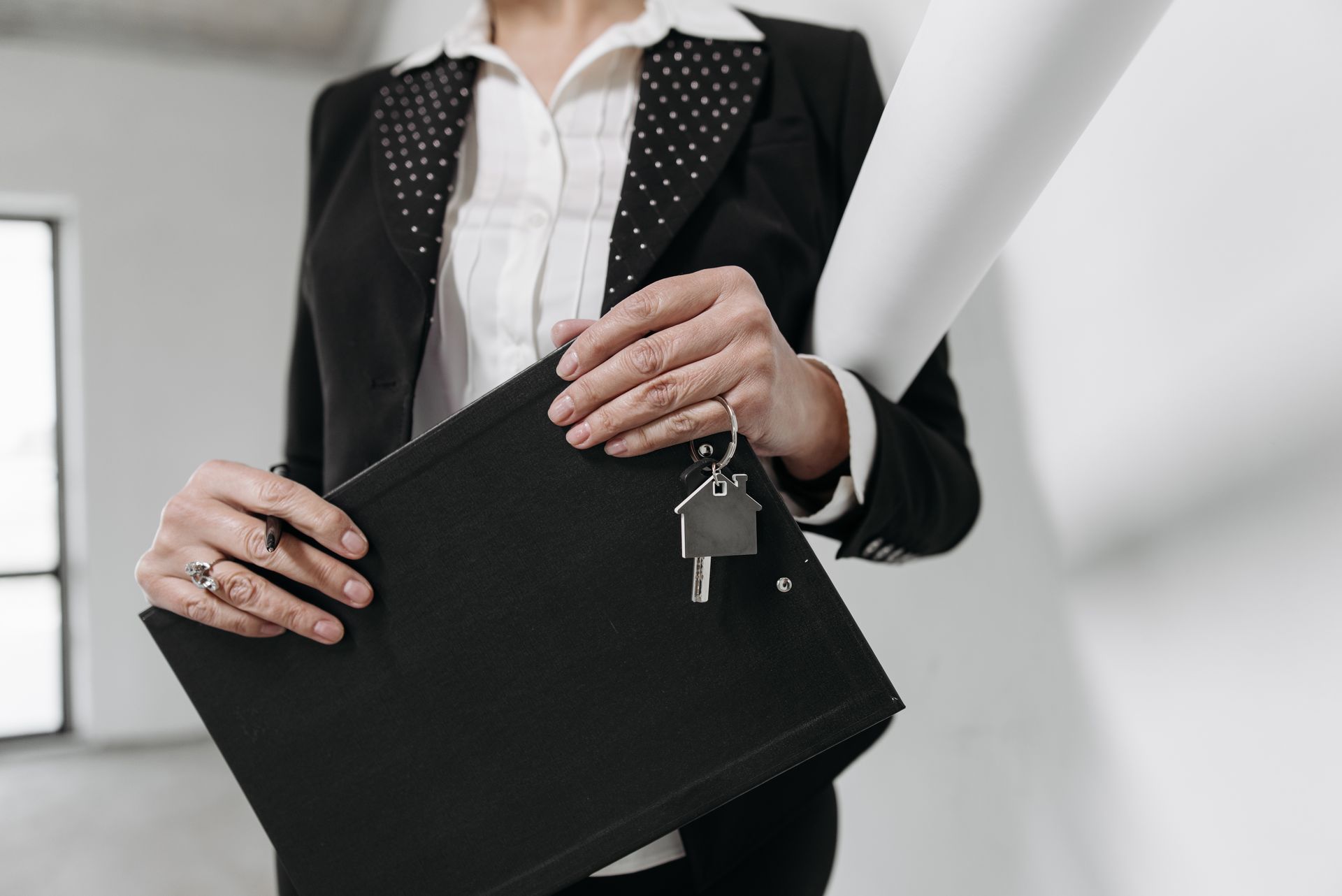 Real estate agent holding a folder and house keys ready for bookkeeping