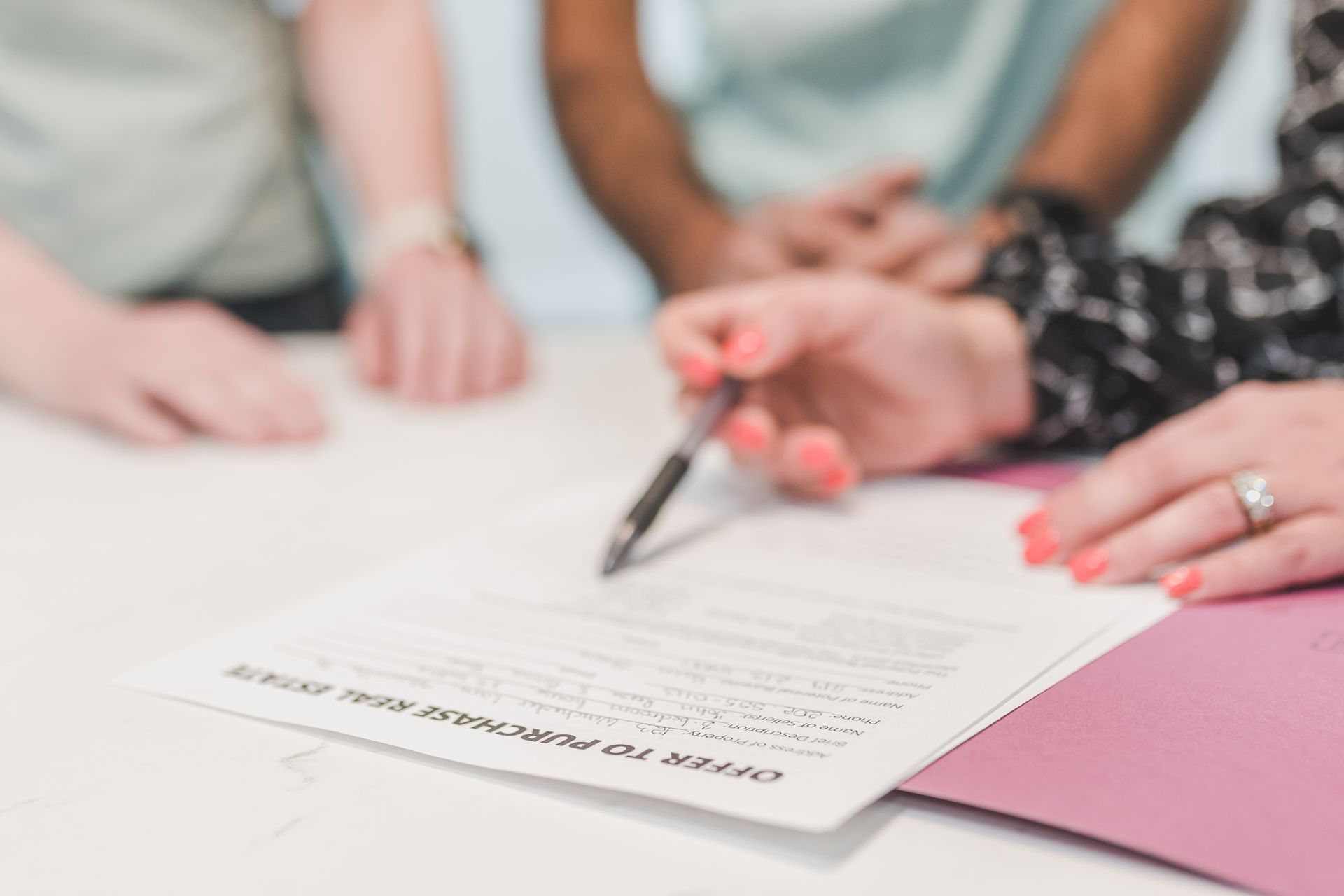 Couple signing an offer to purchase real estate, the kind of sale that can involve taxable Canadian property