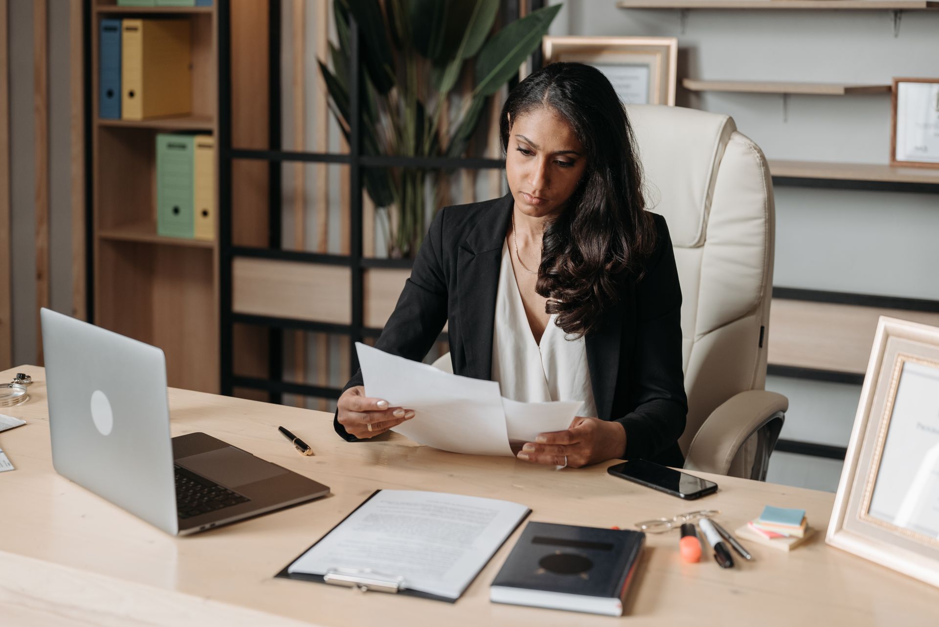Professional woman reviewing tax documents at her desk as part of high income tax planning
